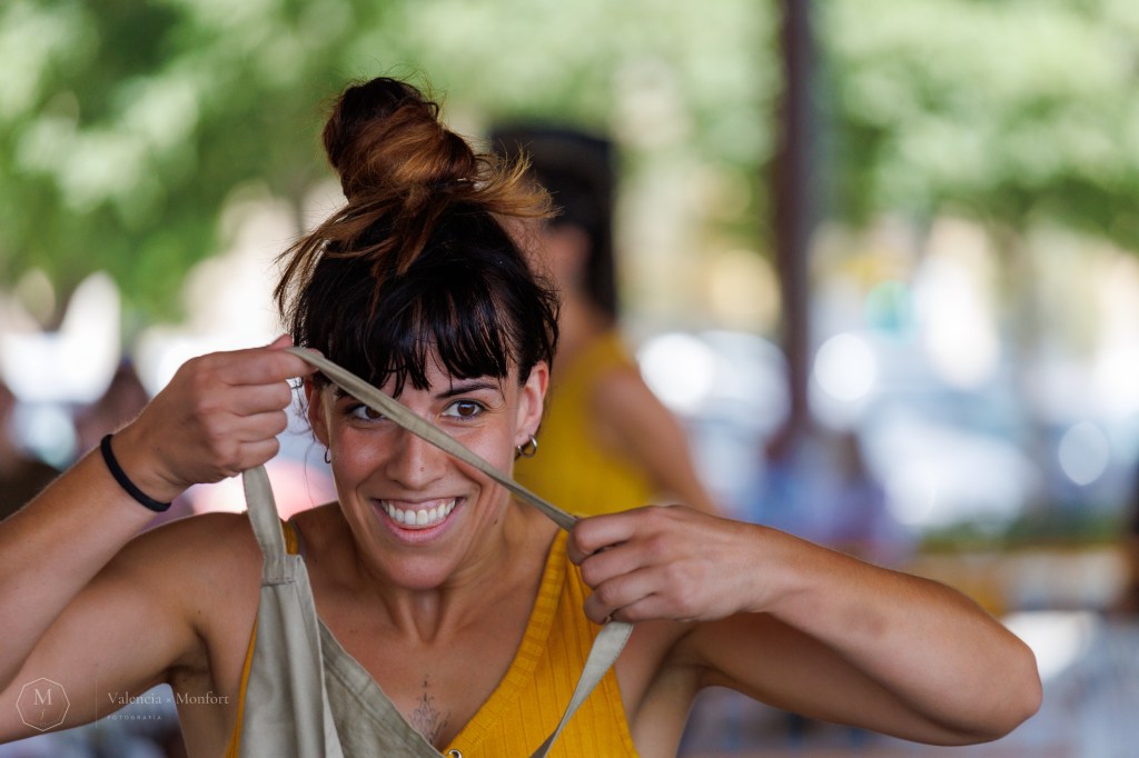 Una artista del festival Contorsions sonríe mientras se ajusta los tirantes, con el fondo desenfocado