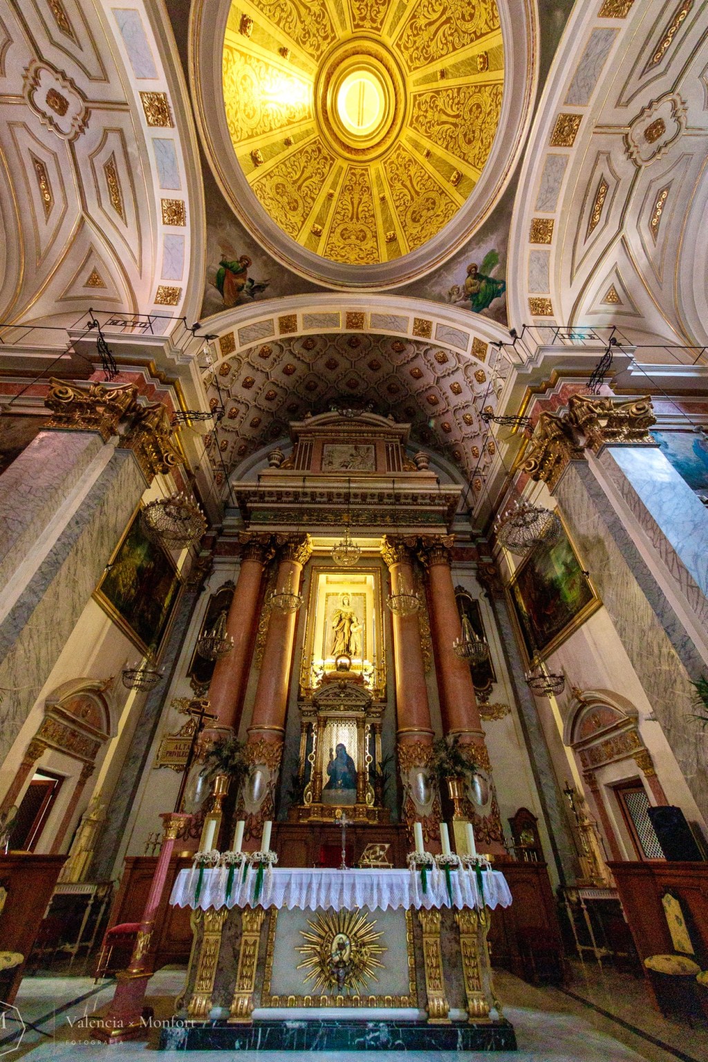 Retablo mayor de Santa Mónica bajo la cúpula dorada, con el altar y sus candelabros